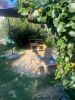 Garten mit Sandkasten und Spielsachen unter Sonnenschutz